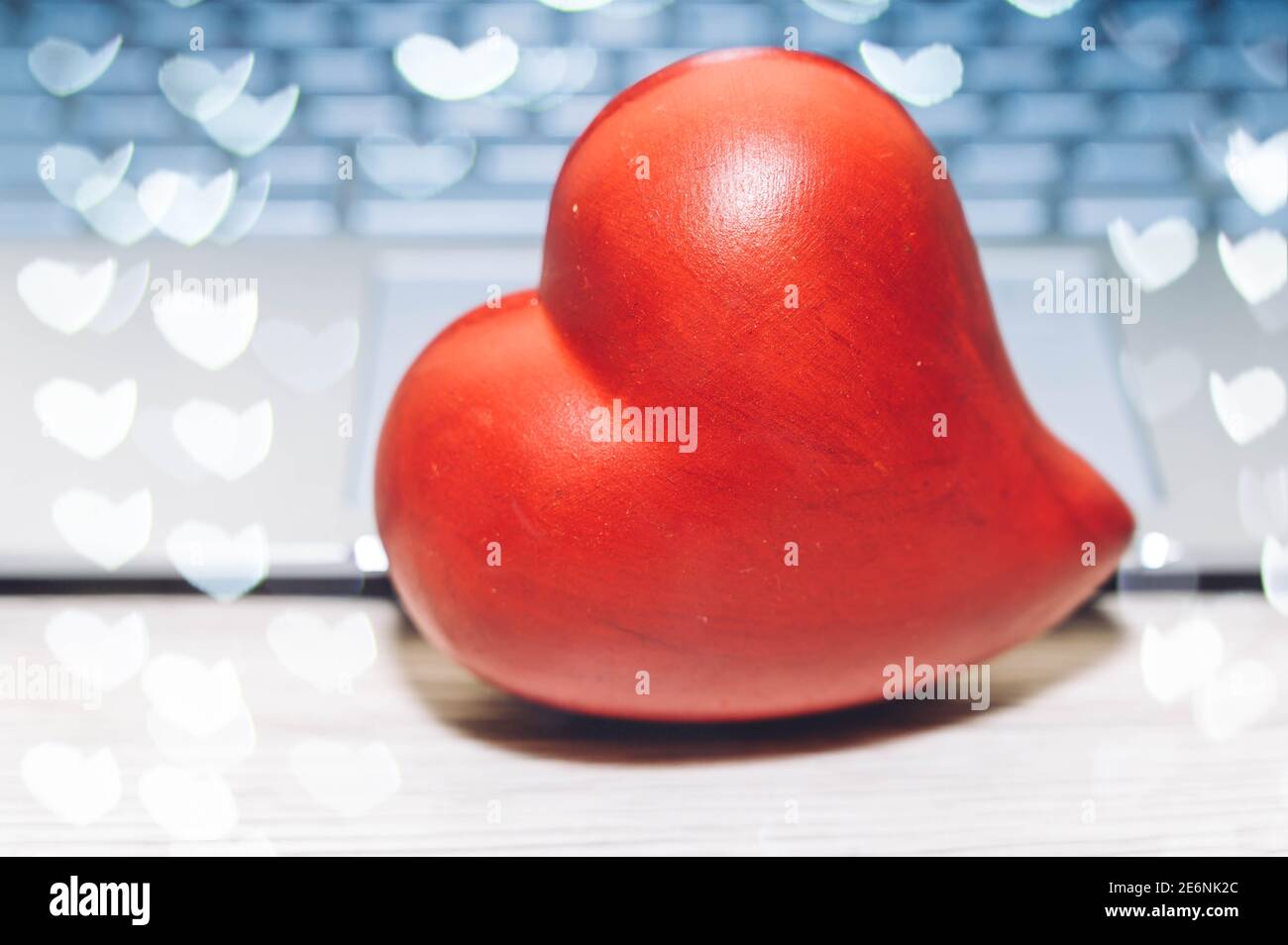 Cuore rosso e tastiera per computer portatile su un tavolo di legno. Internet dating, concetto di giorno di San Valentino. Foto Stock