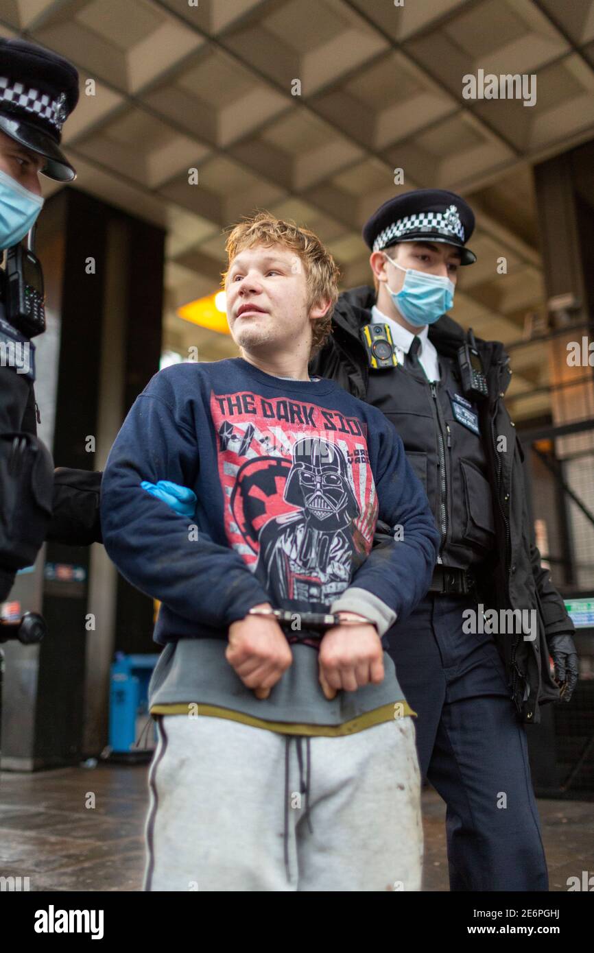 Sfratto di manifestanti Stop HS2 dal campeggio a Euston Square Gardens, Londra, 27 gennaio 2021. Un giovane protestore viene arrestato. Foto Stock