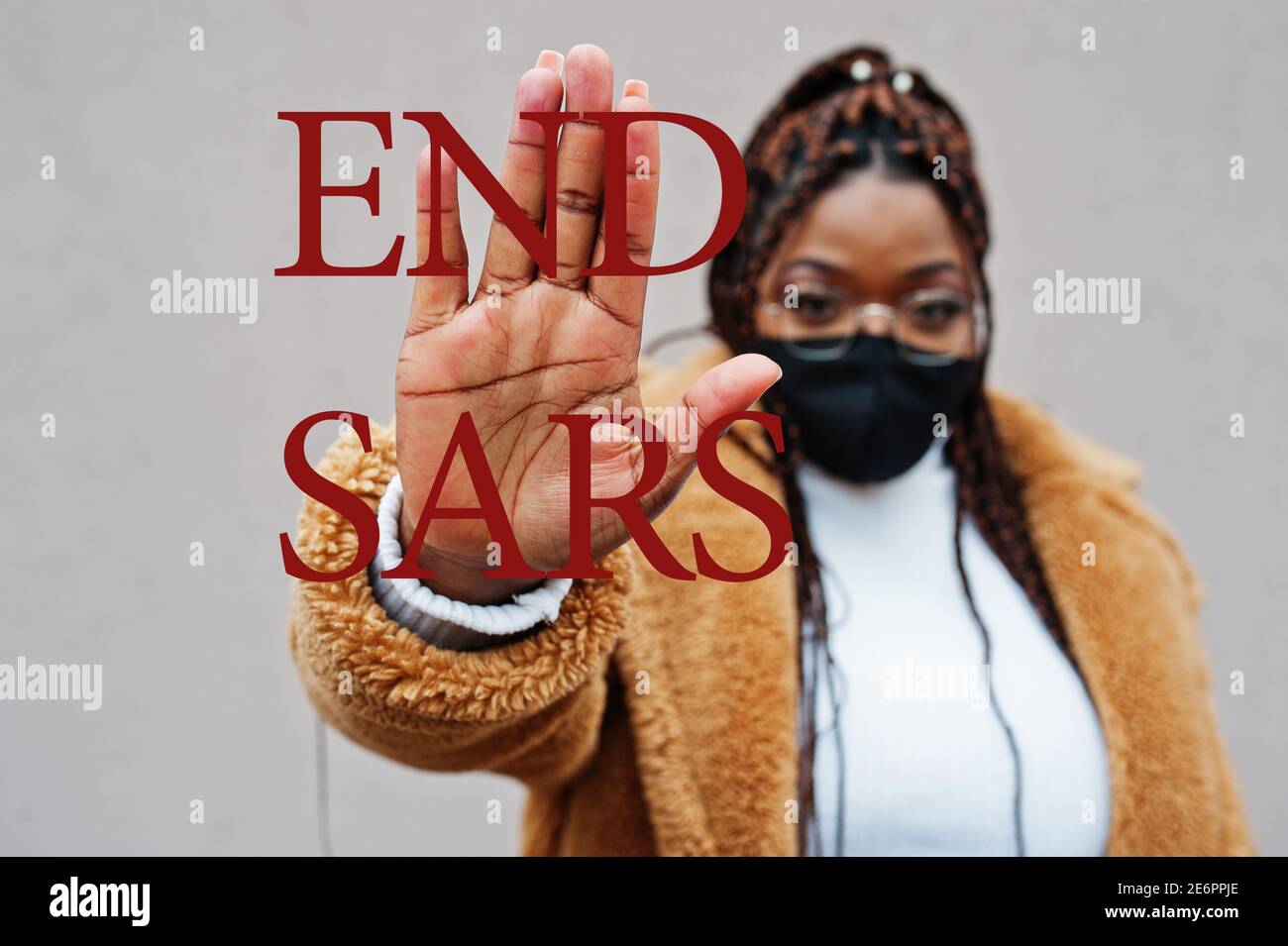 Fine SARS. Donna afroamericana, indossare maschera nera mostra segno di stop mano. Foto Stock