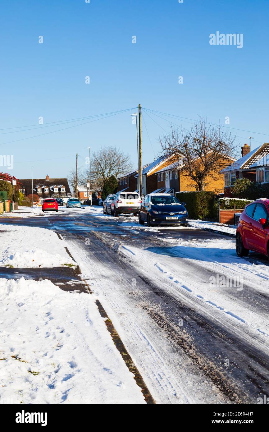 Strada residenziale coperta di neve con auto parcheggiate. Grantham Lincolnshire, Inghilterra Foto Stock