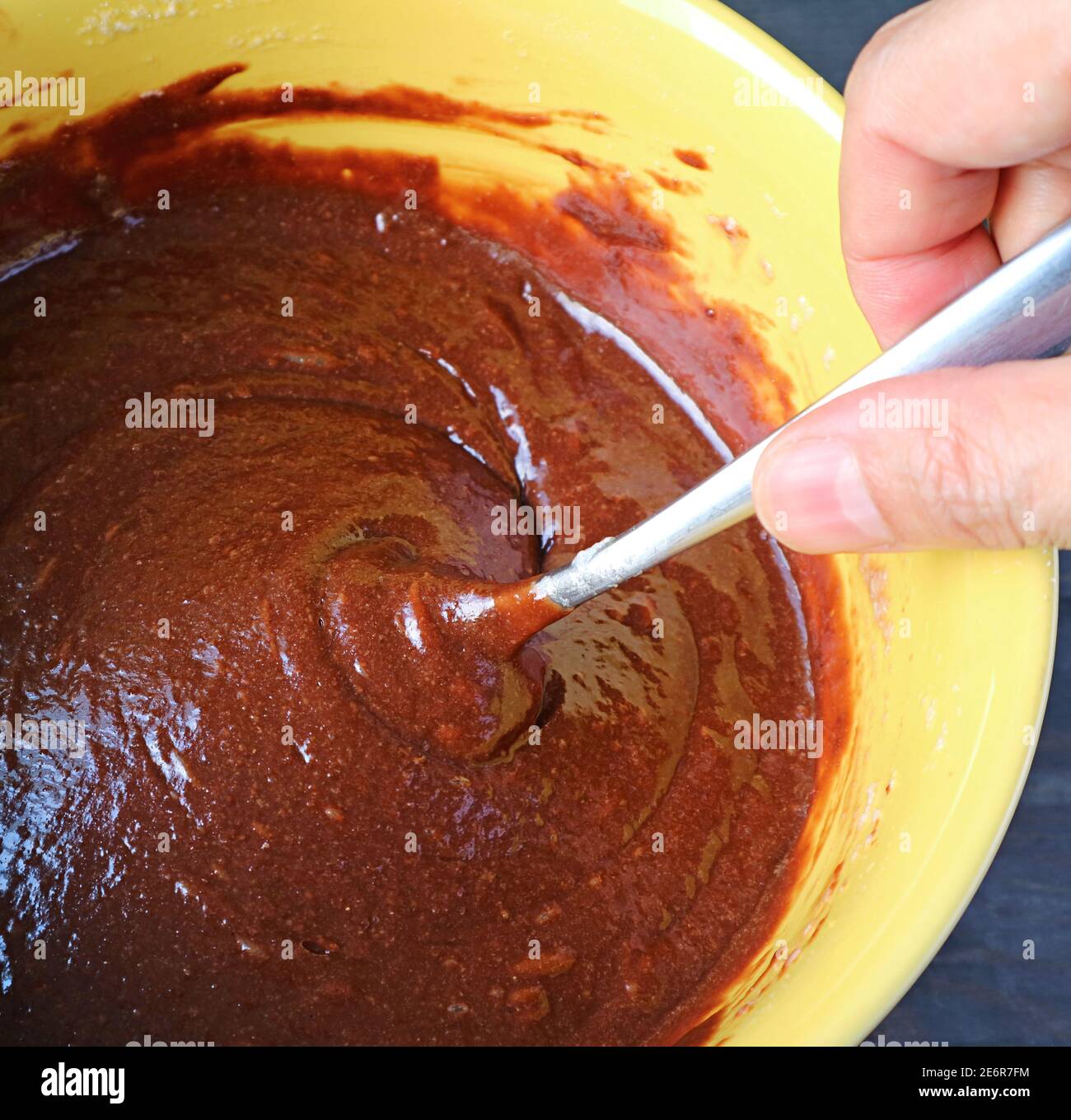 Mescolare a mano gli ingredienti per cuocere un sano e gustoso Torta integrale all'olio di oliva al cioccolato Foto Stock