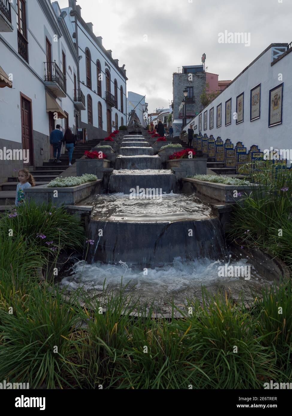 Firgas, Gran Canaria, Isole Canarie, Spagna 13 dicembre 2020: Vista di via Paseo de Gran Canaria con fontana a cascata, fiori e ceramica Foto Stock