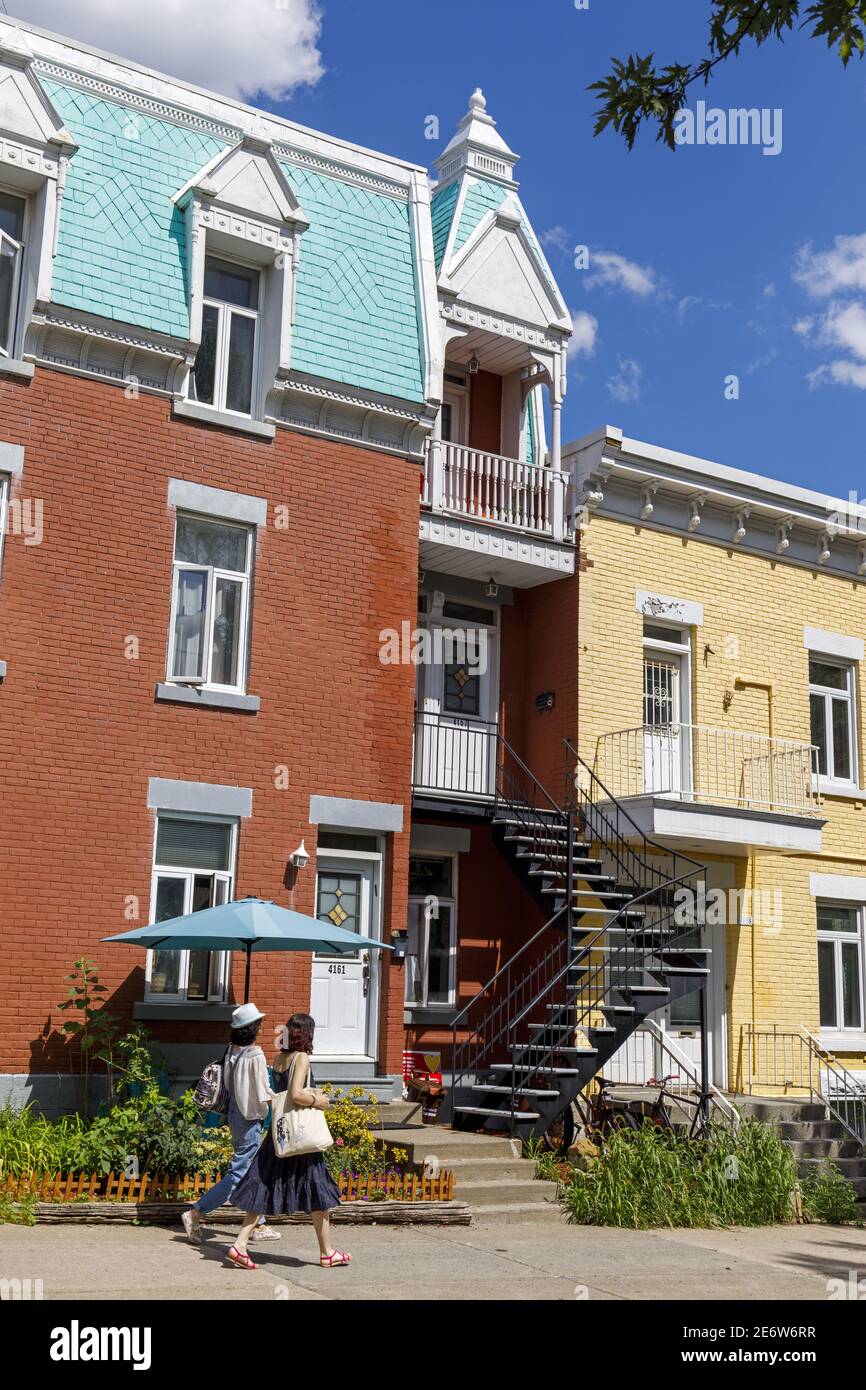 Canada, provincia di Quebec, Montreal, il quartiere Plateau-Mont-Royal, case colorate con scala in ferro tipica della città e passanti Foto Stock