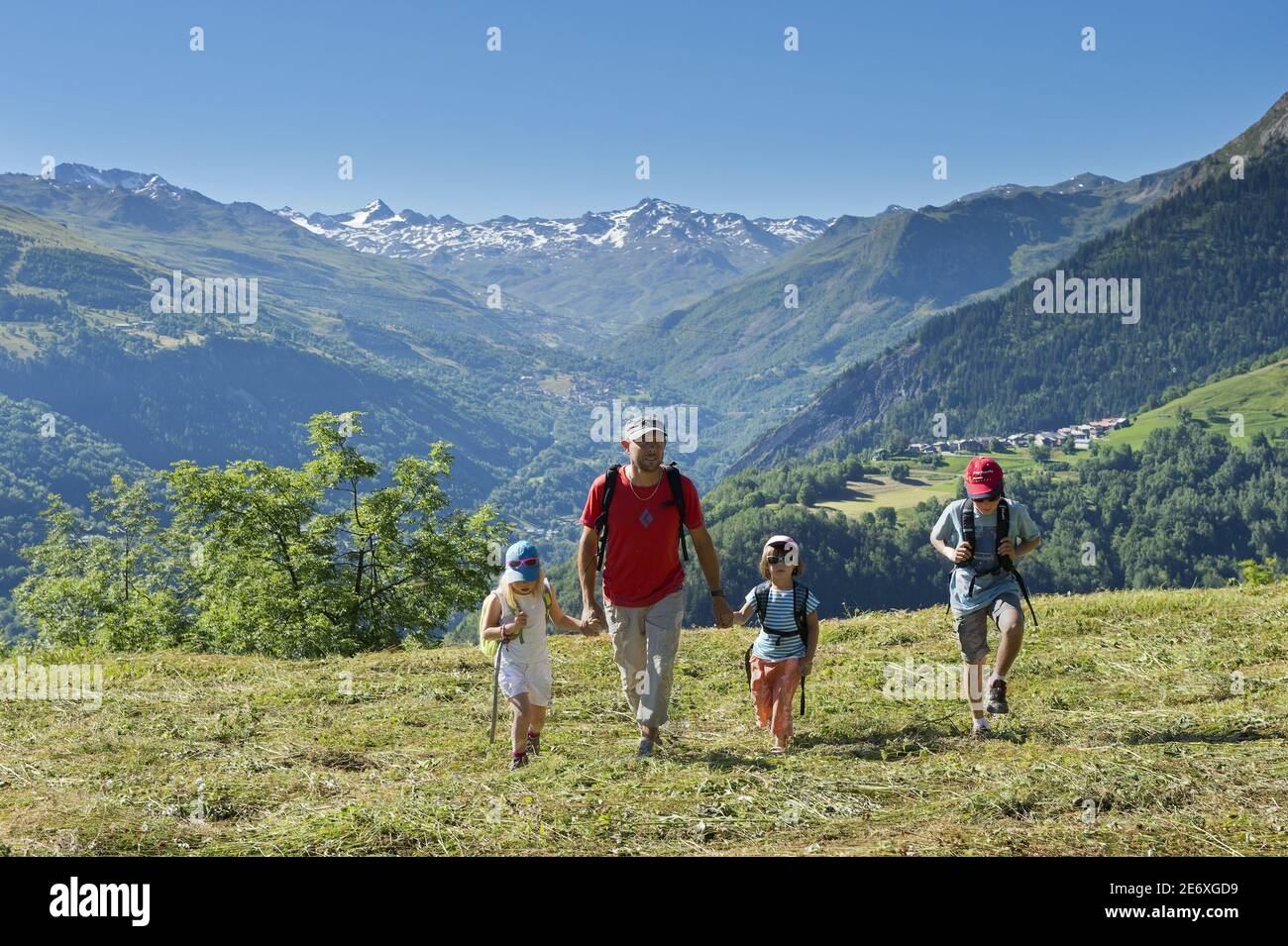 Francia, Savoia, massiccio della Vanoise, le 3 valli, Saint Martin de Belleville, Pere e i suoi tre figli in una passeggiata sopra Saint Jean de Belleville e che domina la valle di Belleville Foto Stock