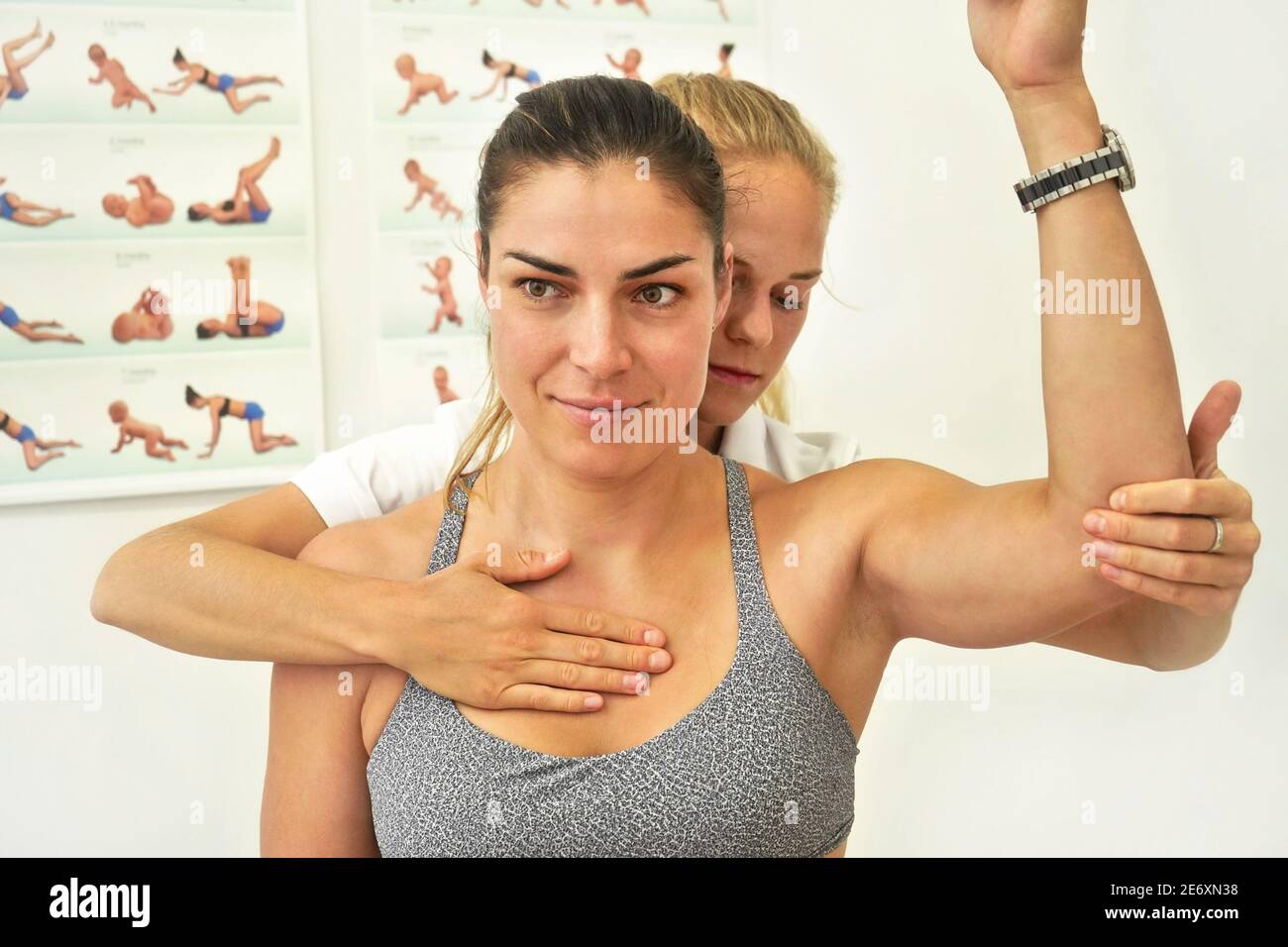 Giovane donna fisioterapista che si esercita con la sua paziente femminile, tenendo il gomito e allungando i muscoli Foto Stock