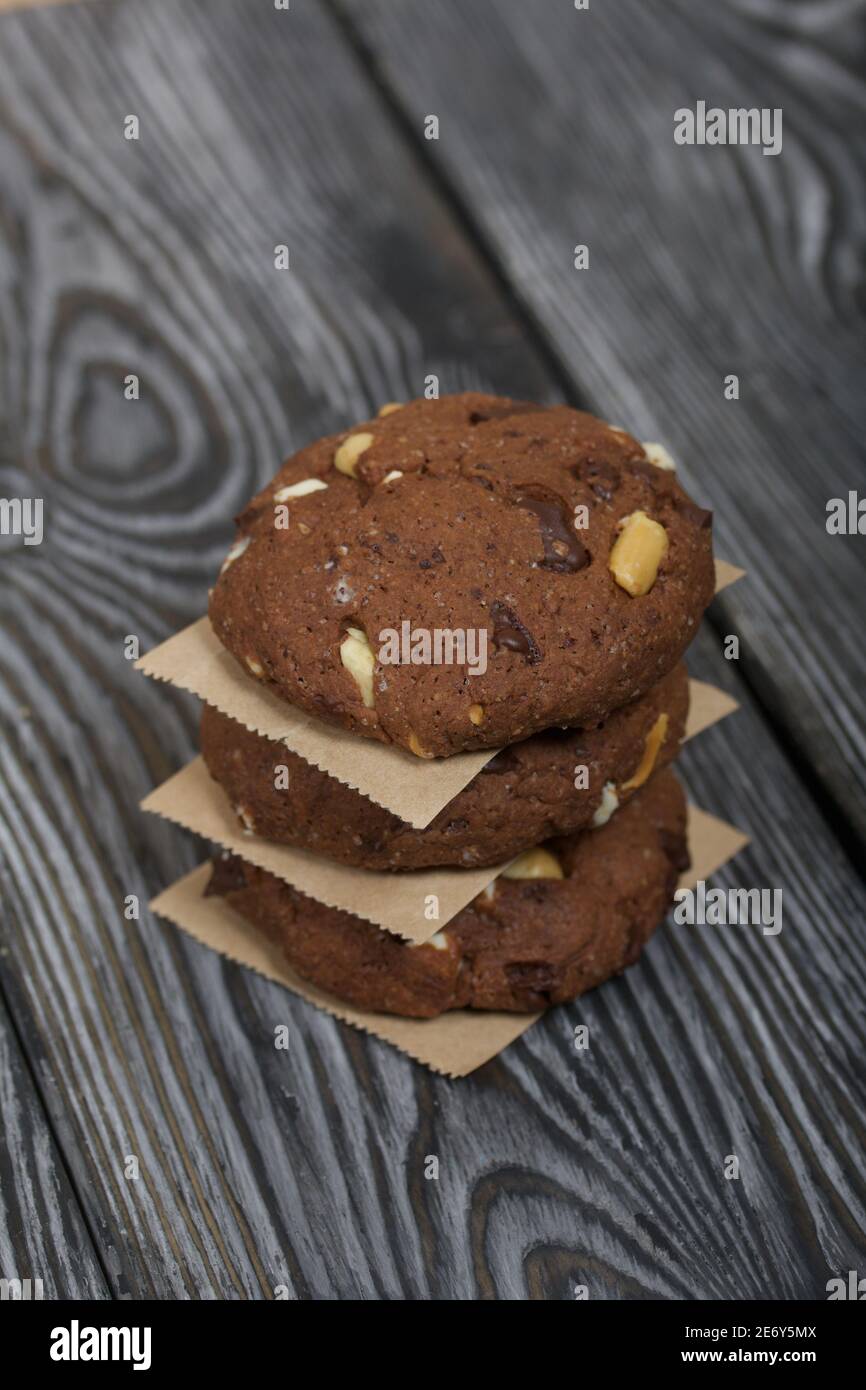 Biscotti di farinata d'avena con arachidi e cioccolato. Piegato in una  colonna e steso con carta. Su tavole di pino Foto stock - Alamy