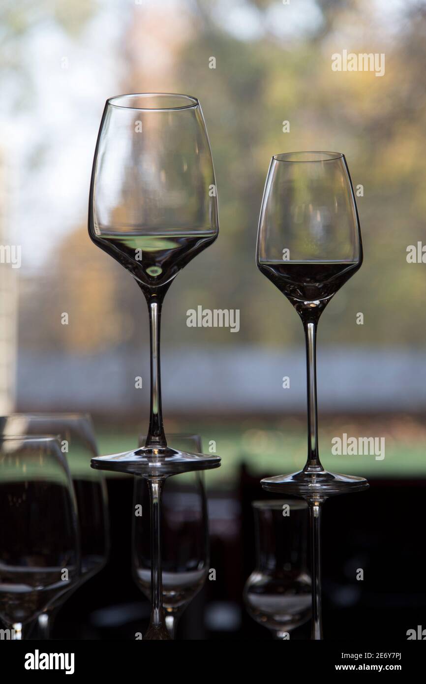La fila di bicchieri da vino su un davanzale. Lo sfondo è sfocato. Foto Stock