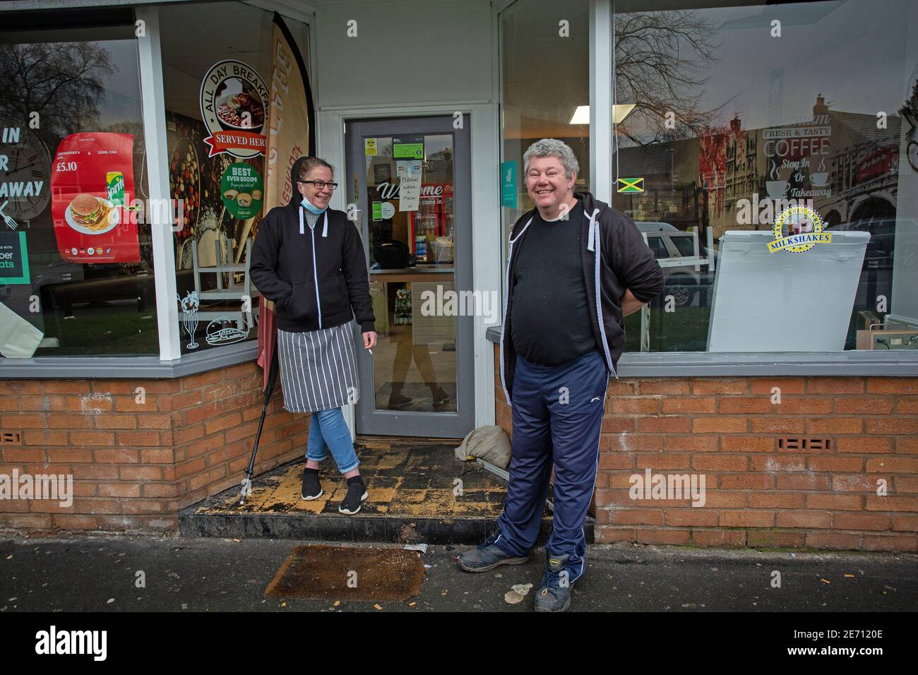 Il proprietario di caffè femminile e maschile di fronte al loro caffè a Manchester, Regno Unito Foto Stock