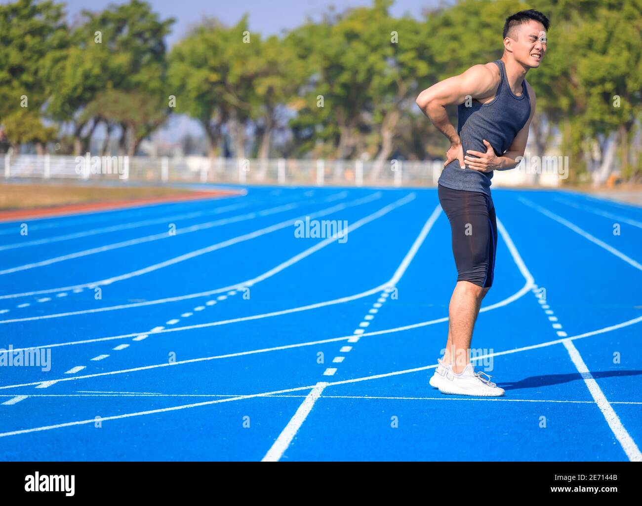 Giovane uomo di idoneità che tiene la sua ferita di sport, muscolo doloroso durante l'addestramento Foto Stock