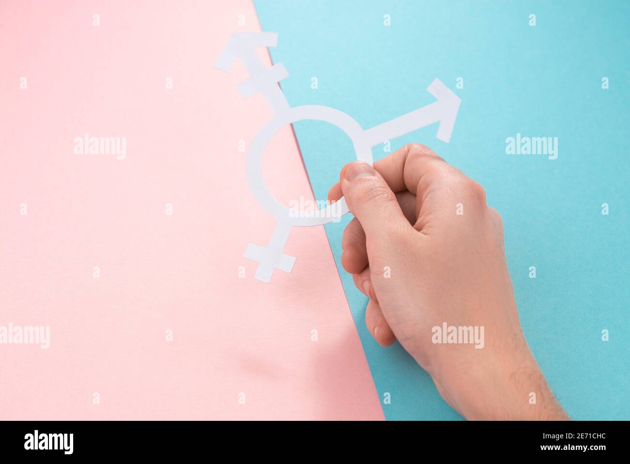 Mano tenendo un segno di trans persone su rosa e. sfondo blu Foto Stock