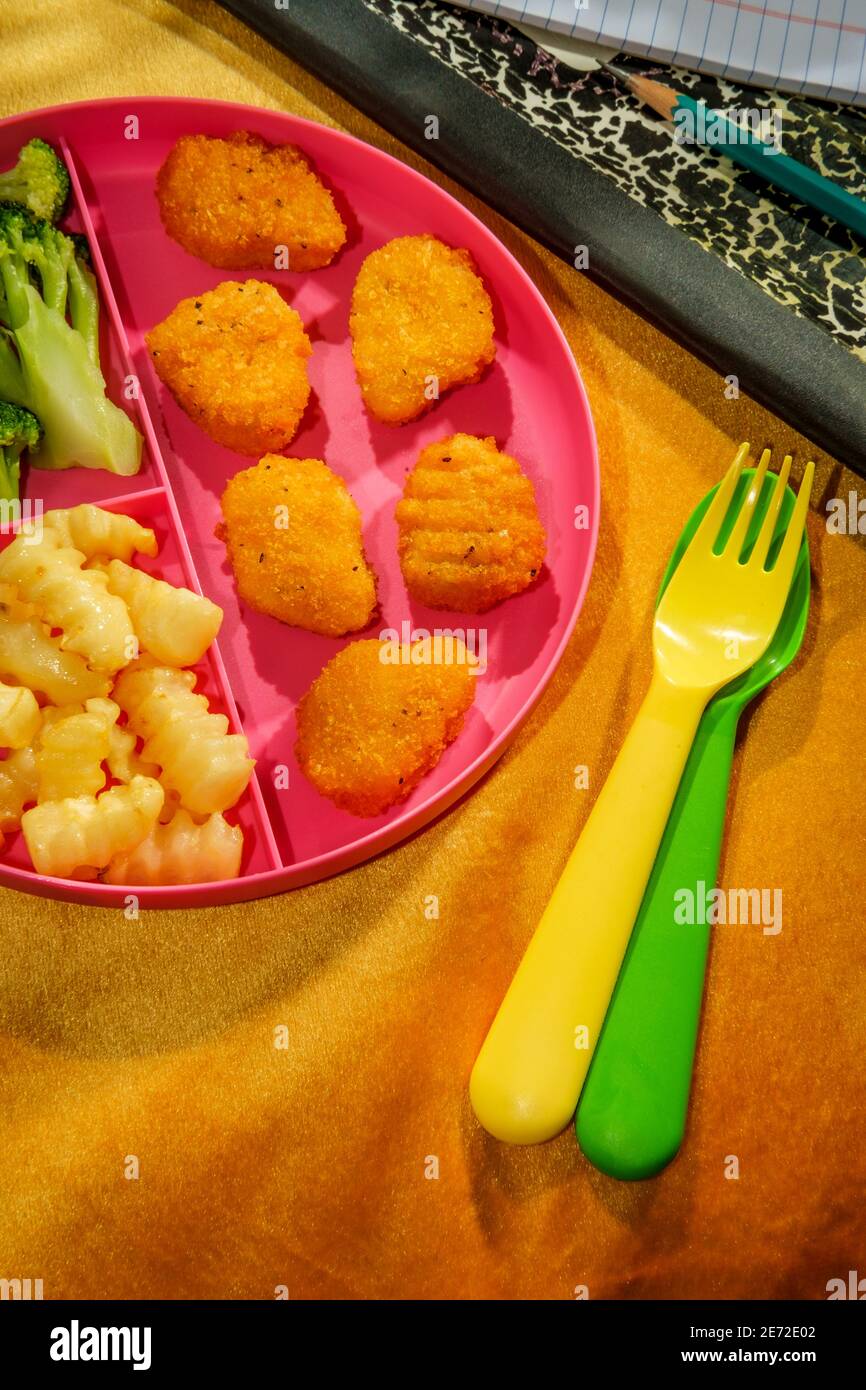 A casa scuola di pollo nugget pranzo servito su vassoio con patatine fritte e broccoli Foto Stock