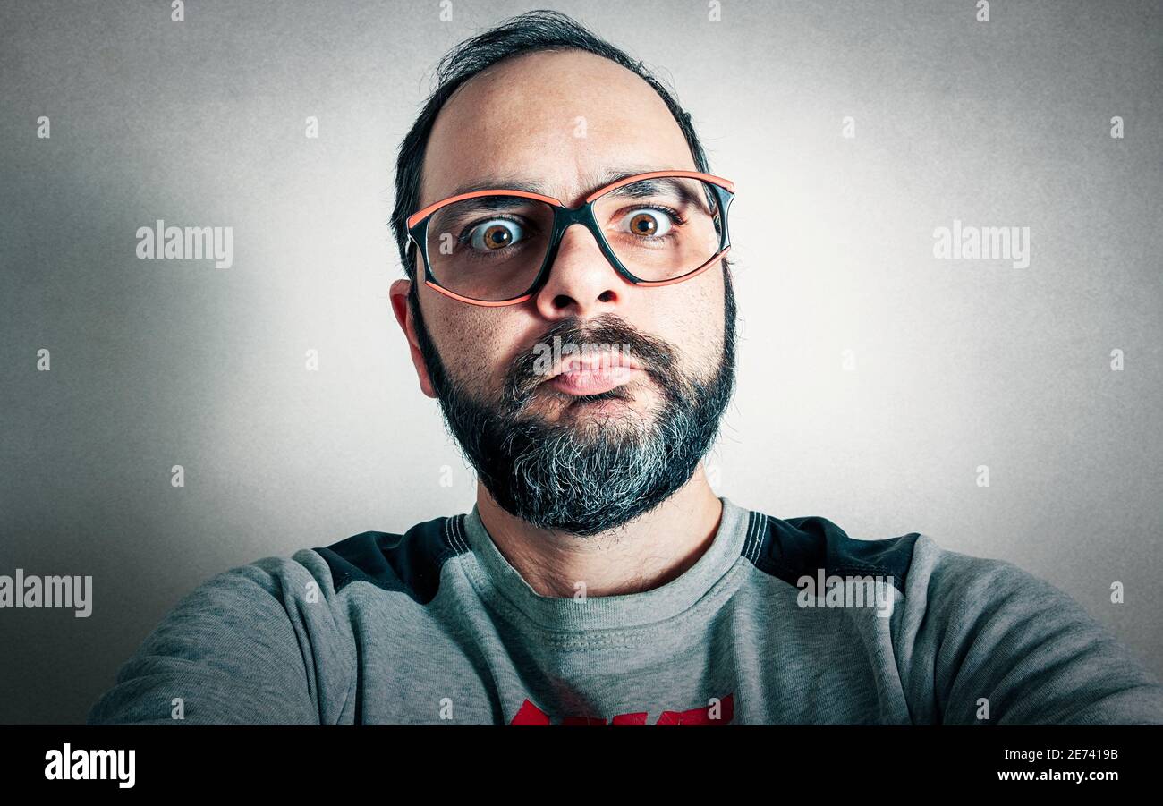 Uomo divertente con la barba che fa espressioni Foto Stock