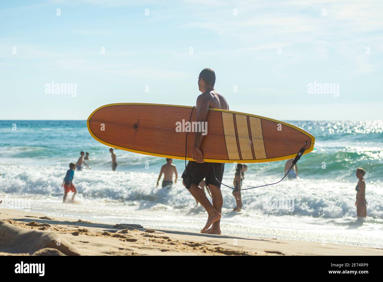 Uomo con tavola da surf tipo longoboboard sulla spiaggia di Biscarrosse. Biscarrosse Plage è un'importante destinazione per il surf sull'Oceano Atlantico in Francia Foto Stock