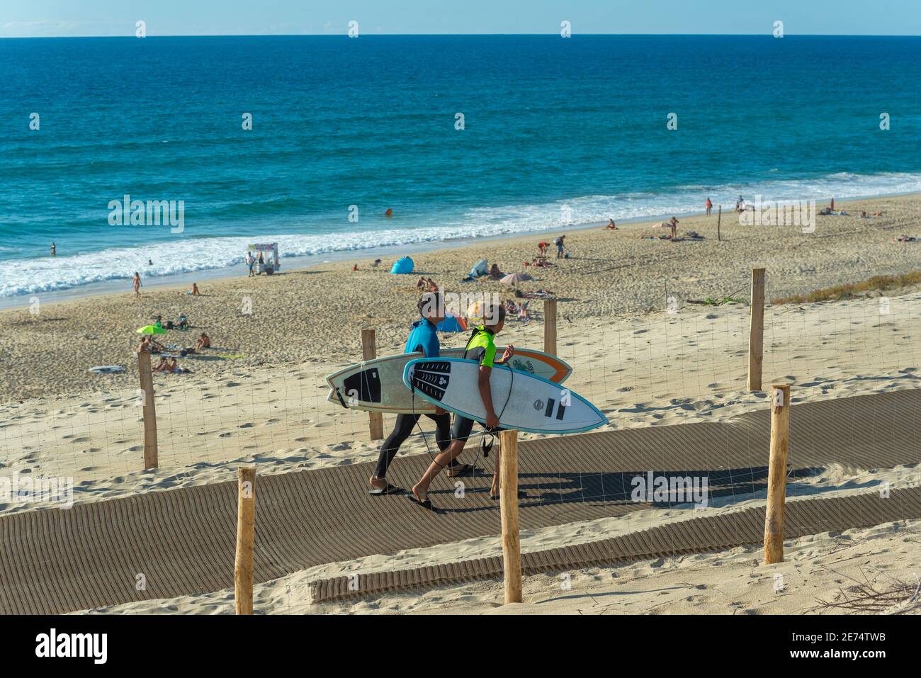 Due giovani con tavola da surf lasciano la spiaggia di Biscarrosse. Biscarrosse Plage è un'importante destinazione per il surf sull'Oceano Atlantico in Francia Foto Stock