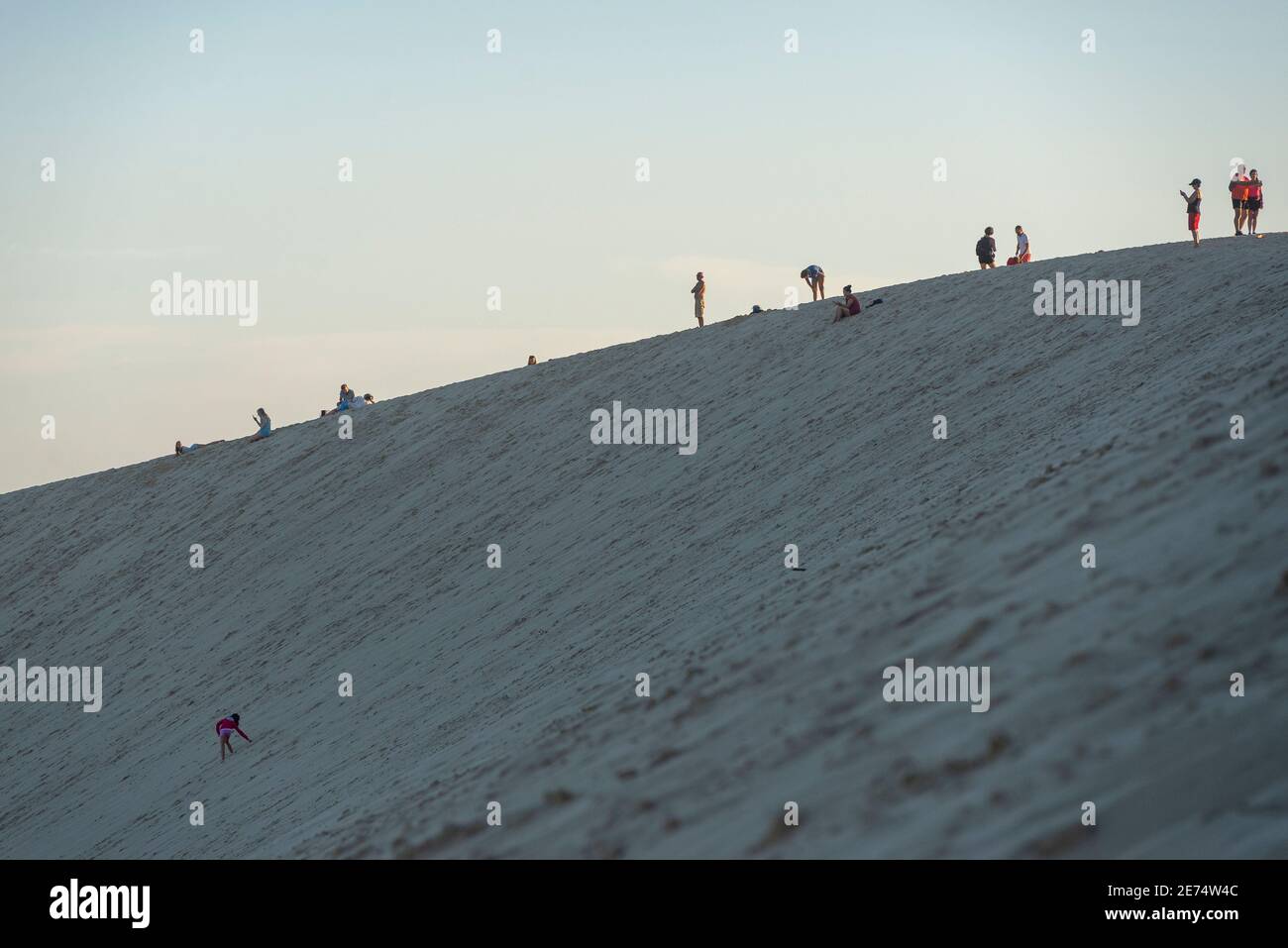 Persone in piedi sulla cima della Dune du Pilat, Landes, Francia. Questa duna di sabbia è la più alta d'Europa e la gente si riunisce lì per guardare il tramonto Foto Stock