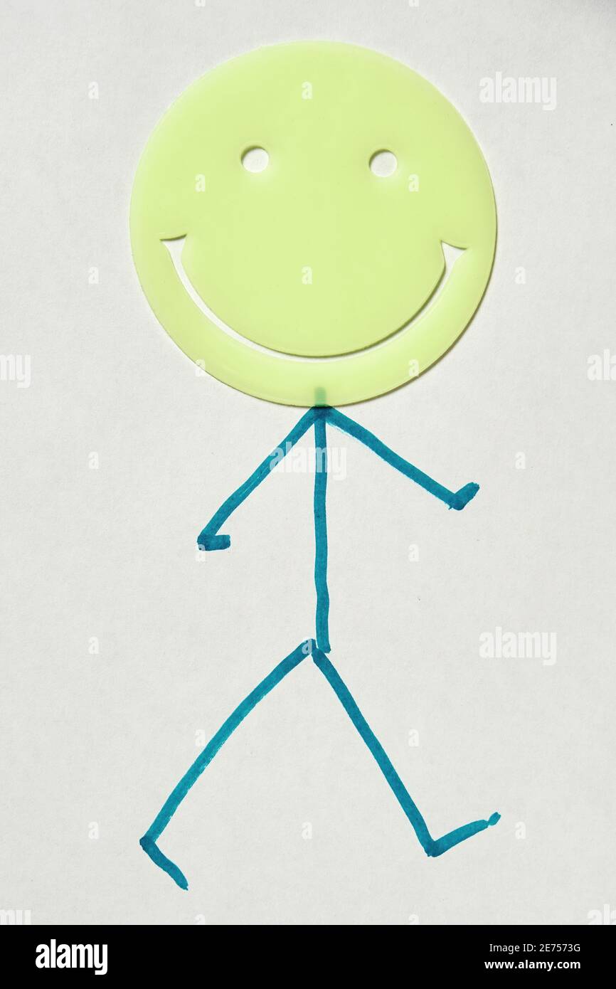 Disegnato uomo camminando con testa emoji rotonda sorridente. Giornata internazionale di felicità simbolo e concetto Foto Stock