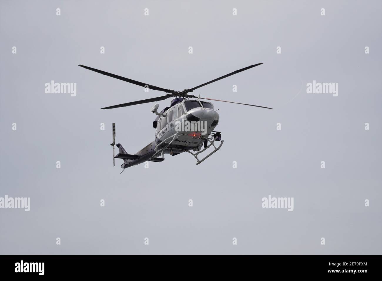 Elicottero della polizia contro un cielo grigio Foto Stock