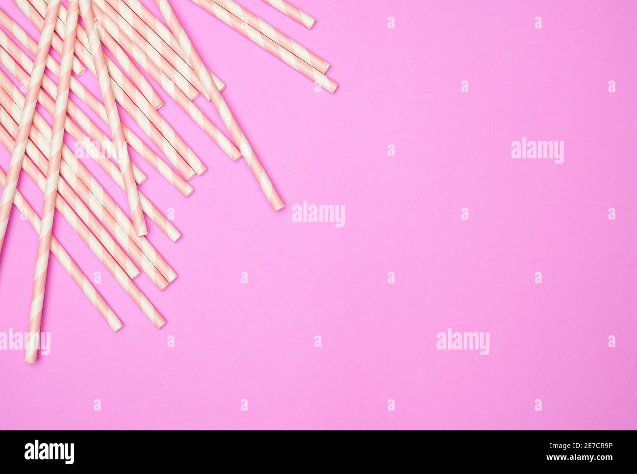 Disposizione piatta con cannucce da bibita a righe su sfondo rosa Foto Stock
