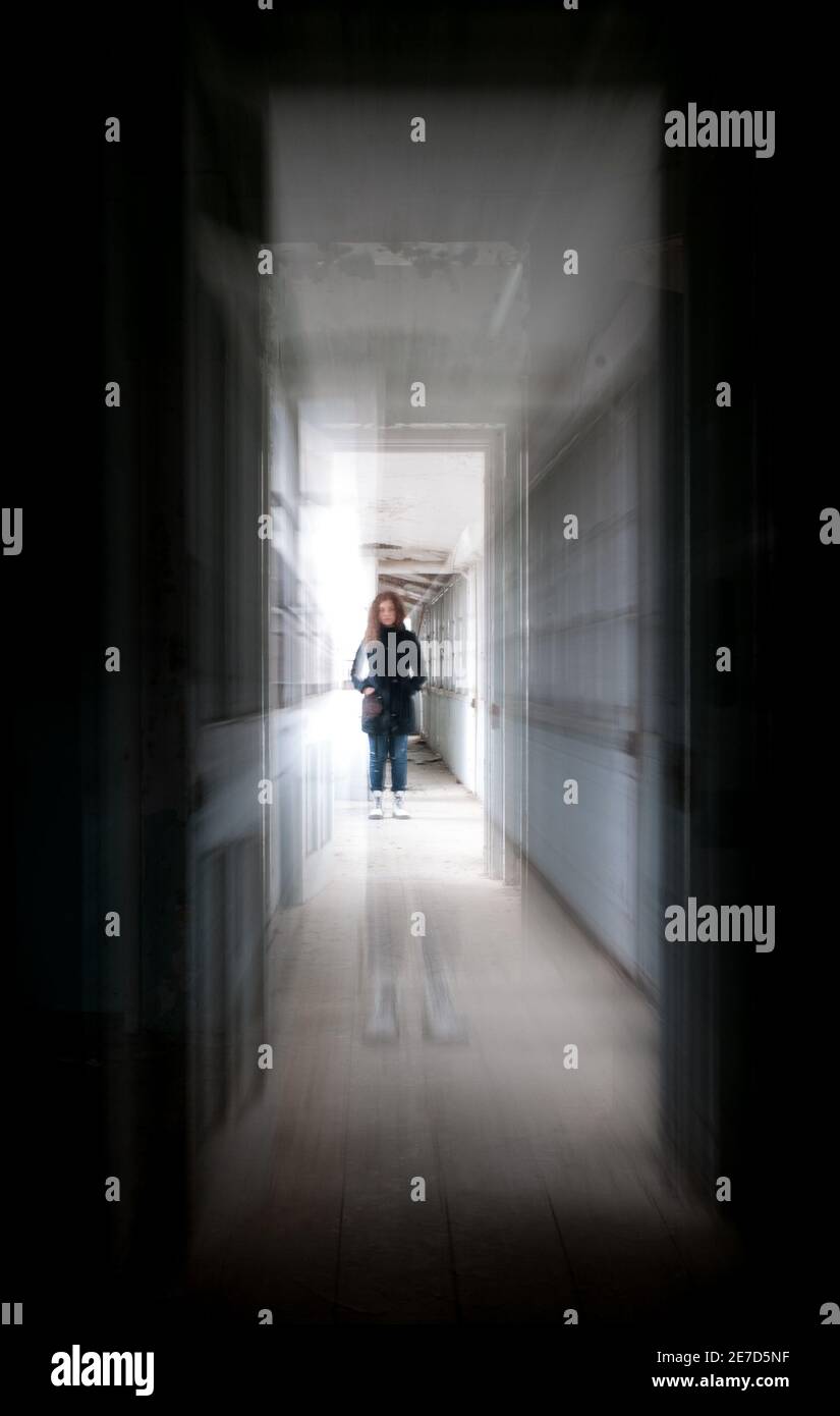 Scuro creepy scuro corridoio con una donna al centro Foto Stock