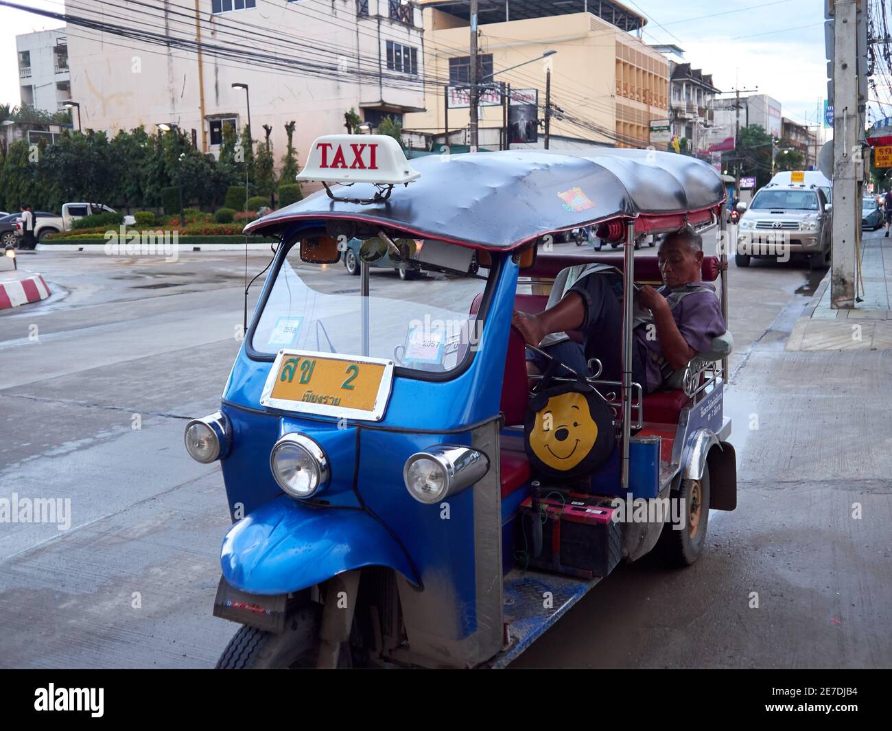 Un tuk thai o un tassista ti aspetta i passeggeri arrivano mentre leggono il giornale Foto Stock