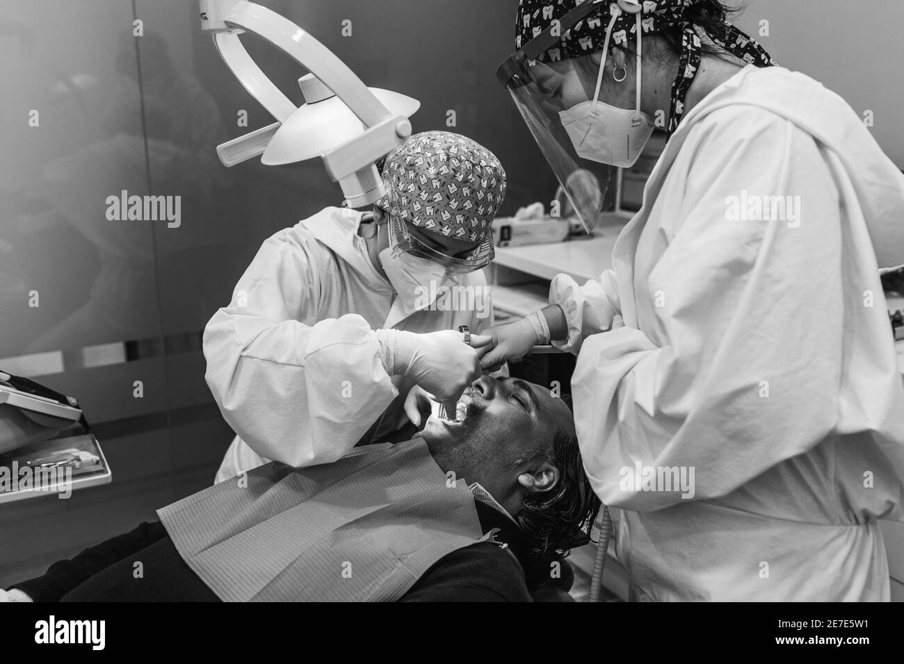Chirurgo dentale che inietta anestesia in bocca. Tre persone. Concetto di salute dentale. Bianco e nero. Foto Stock