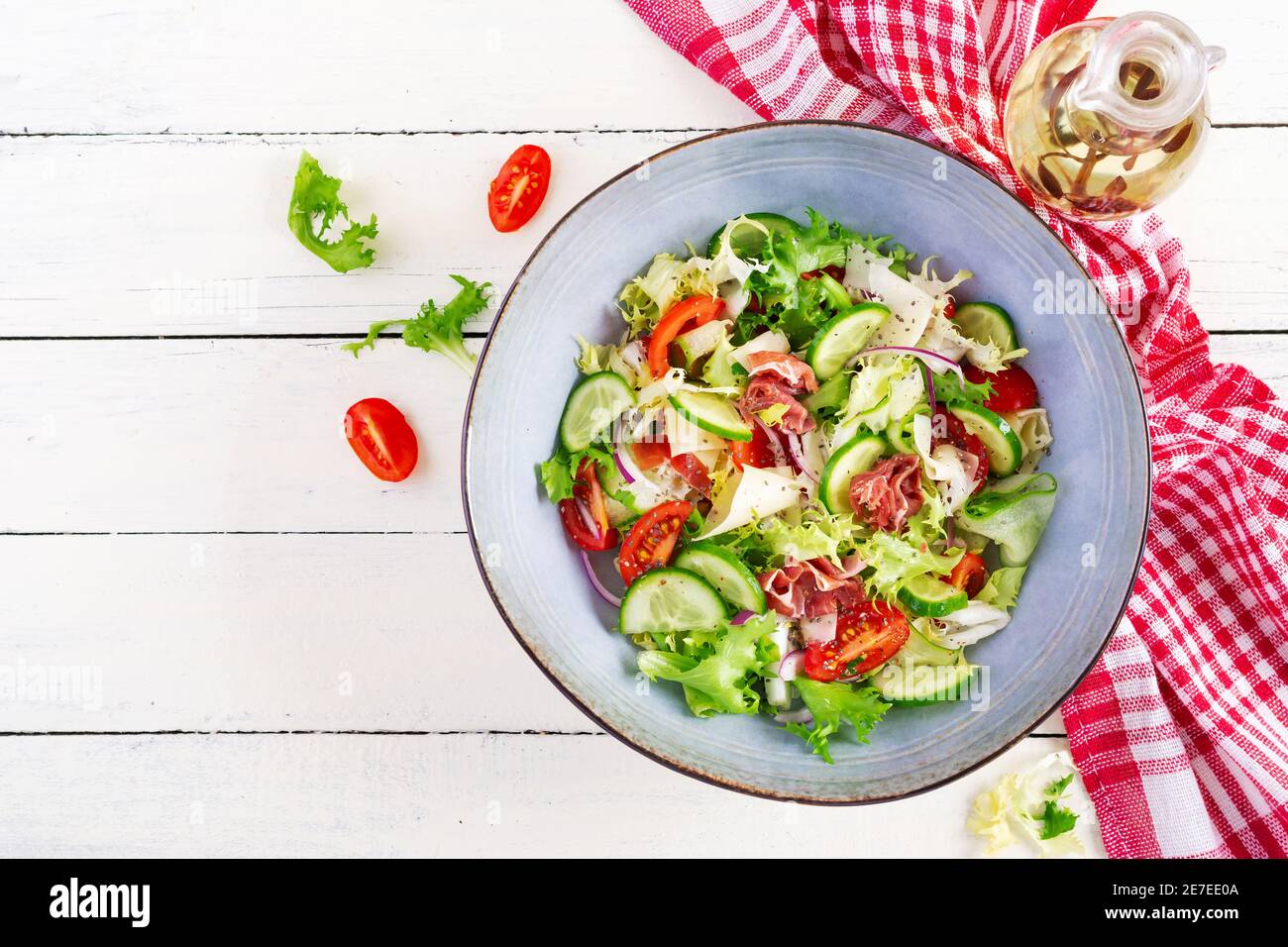 Insalata chetogenica con prosciutto, pomodori, cetrioli, lattuga, cipolla rossa e formaggio in ciotola. Concetto antipasto sano. Keto, cibo paleo. Vista dall'alto, Foto Stock