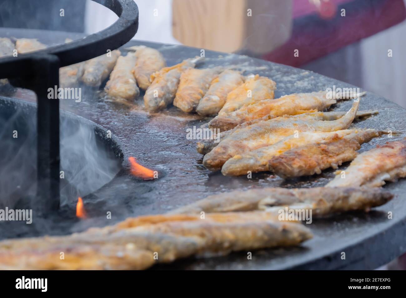 Pesce europeo puzzato croccante su braciere nero all'aperto mercato alimentare Foto Stock