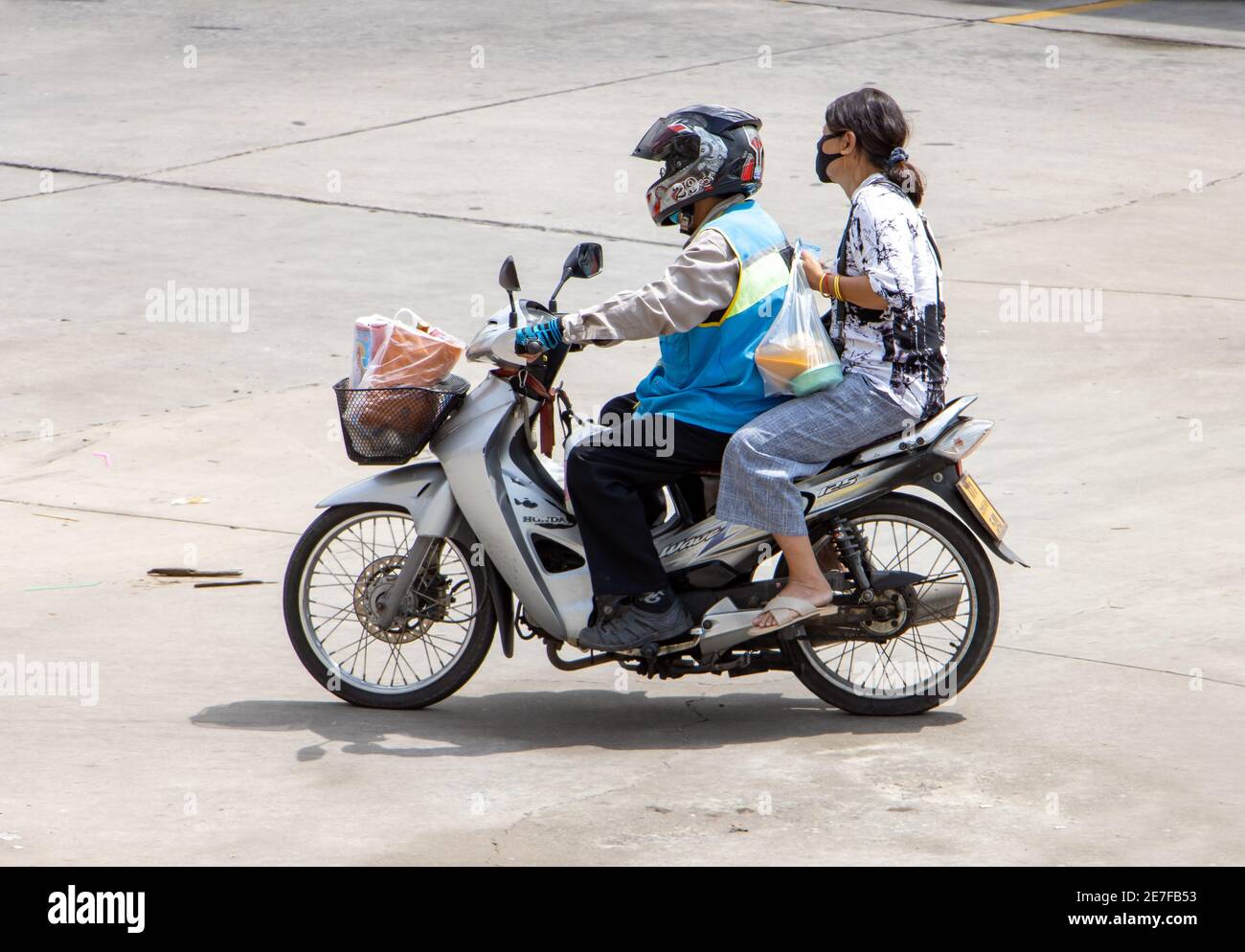 SAMUT PRAKAN, THAILANDIA, 21 2020 LUGLIO, un tassista su una moto giri con una donna. Il conducente del mototaxi trasporta un passeggero. Foto Stock