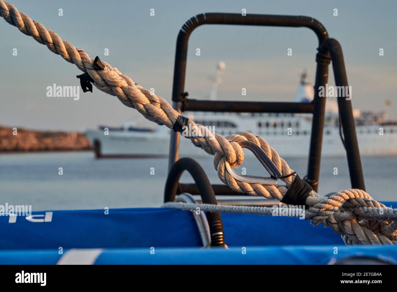 splendido e spettacolare tramonto su un yacht a motore che mostra i dettagli della manipolazione della nave con una barca sullo sfondo sfocato, sdraiata nella ghietta d'acqua Foto Stock