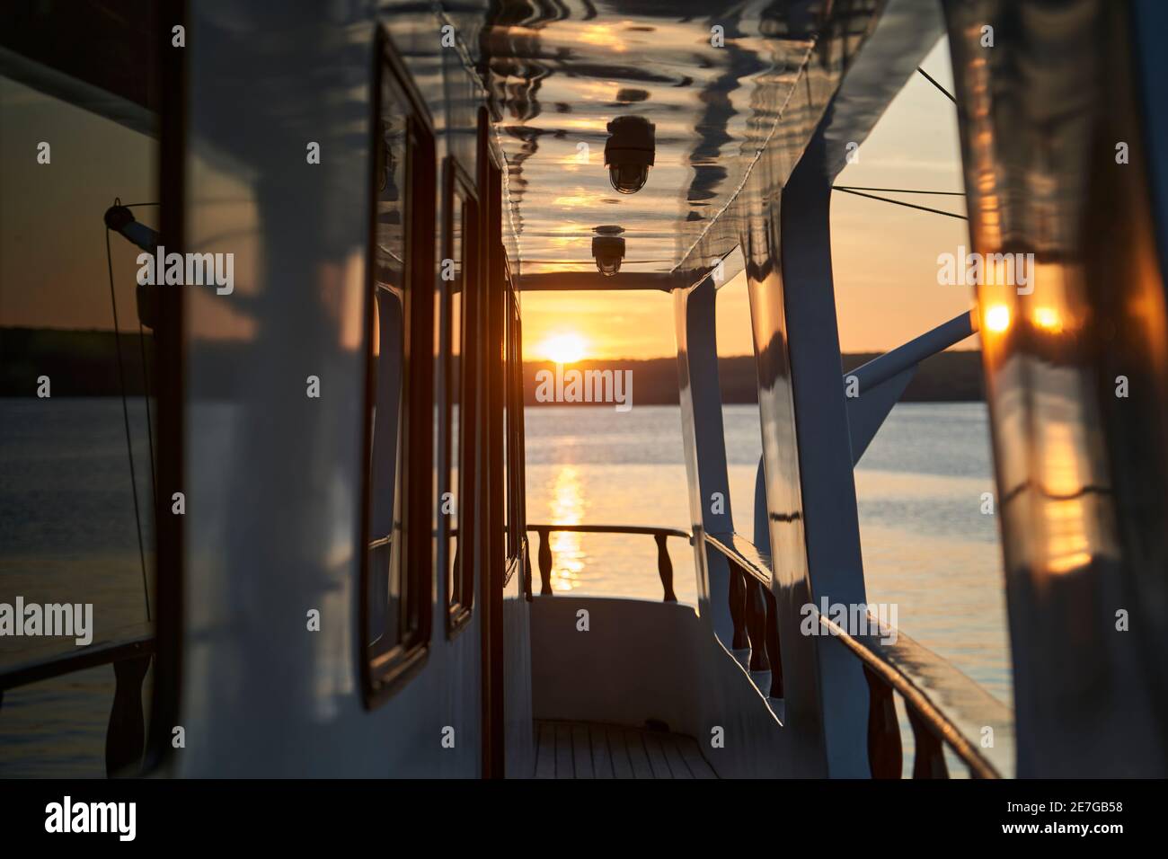 splendido e spettacolare tramonto su uno yacht a motore con riflessi sulla vernice bianca e dettagli dell'imbarcazione, sdraiato nella baia di darwin di ge Foto Stock