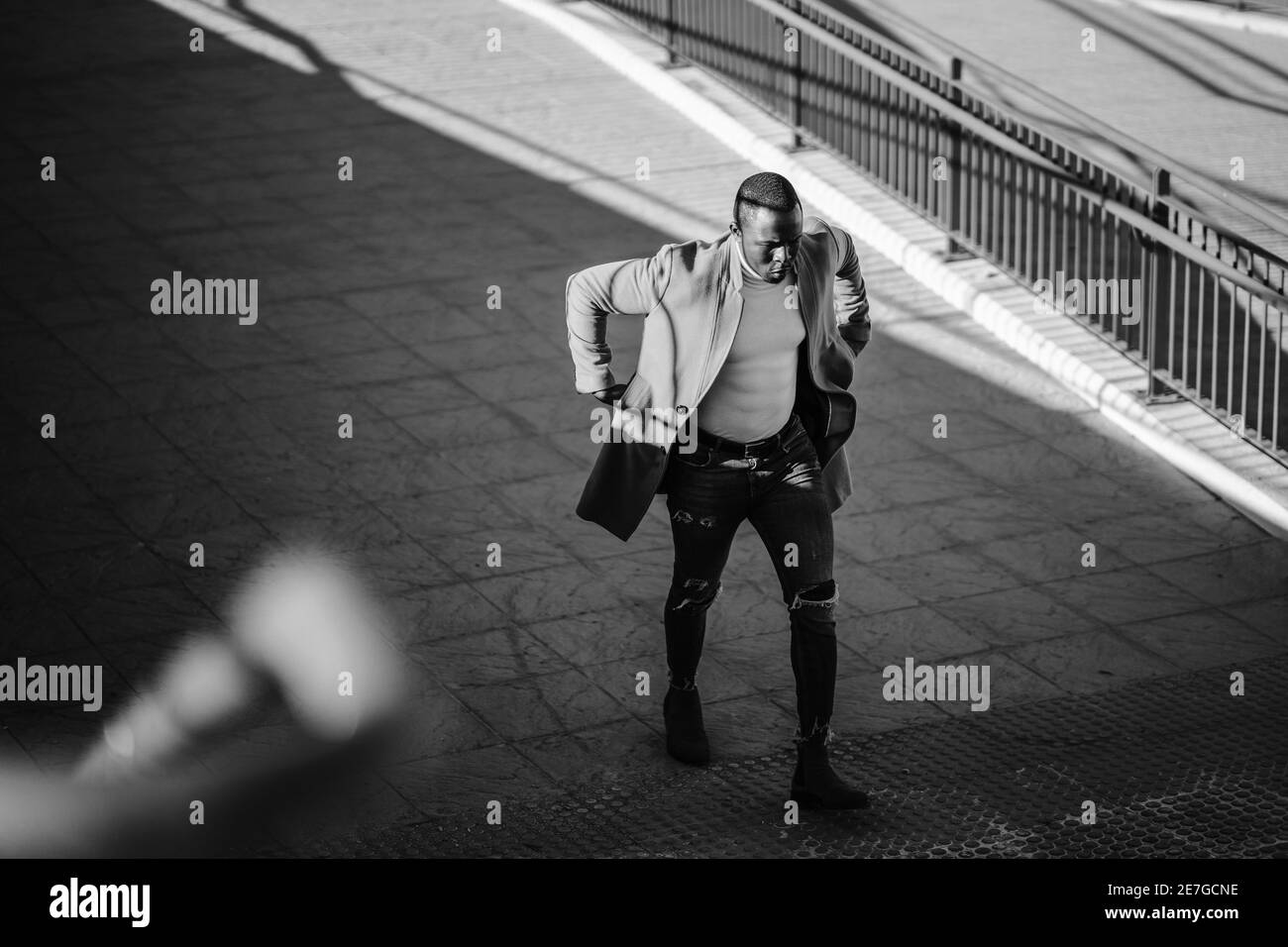 Elegante bel maschio africano in un cappotto che salirà il scale Foto Stock