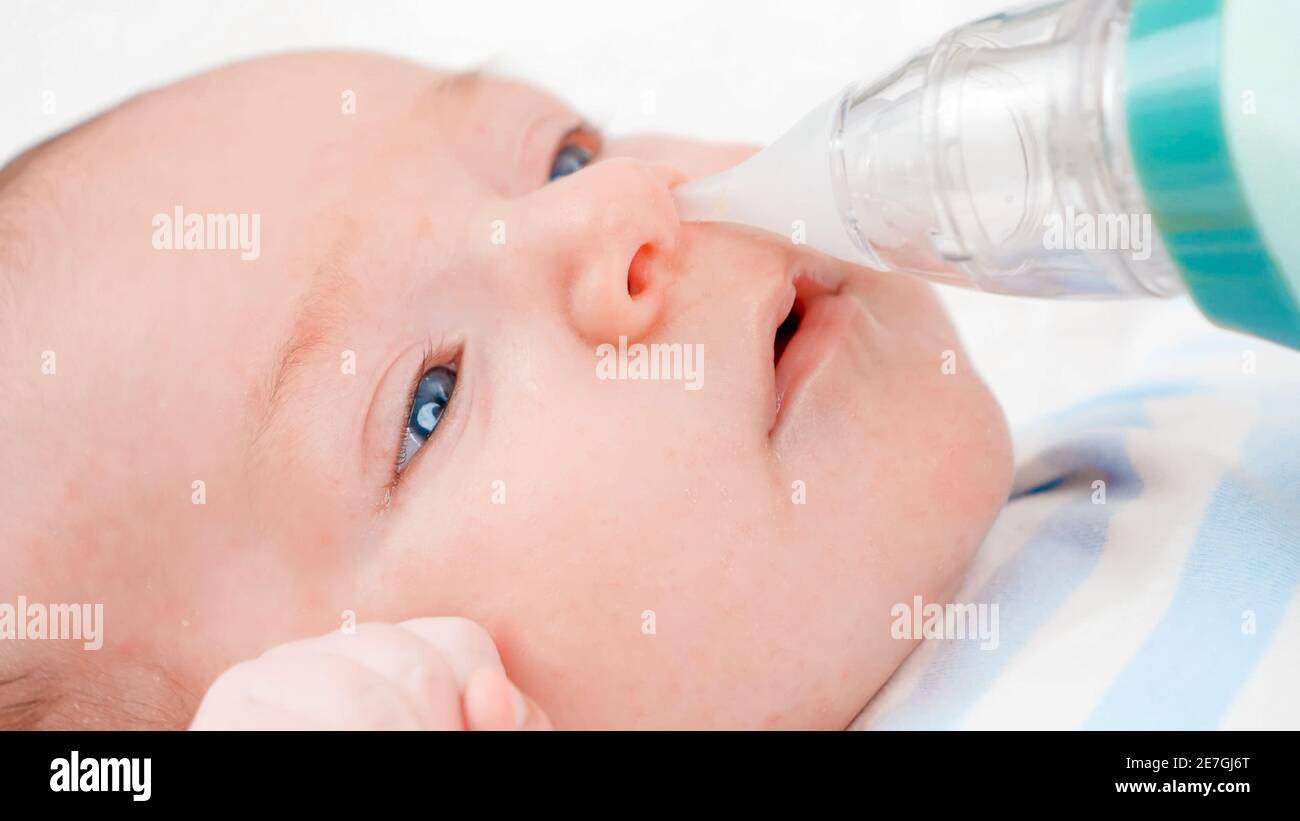 Uso dell'aspiratore nasale per la pulizia del naso del neonato dal muco.  Concetto di igiene e assistenza sanitaria per neonati. Prendersi cura dei  genitori Foto stock - Alamy