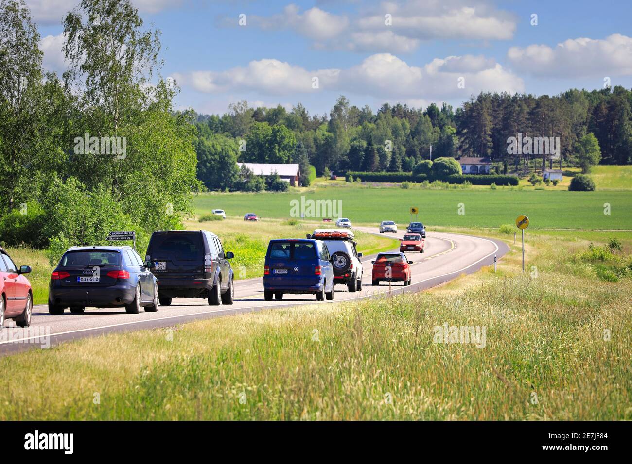 Il traffico lento si è accodato dietro la microcar sulla Main Road 52 finlandese a due corsie il giovedì soleggiato prima della vigilia di metà estate. Salo, Finlandia. 18 giugno 2020 Foto Stock