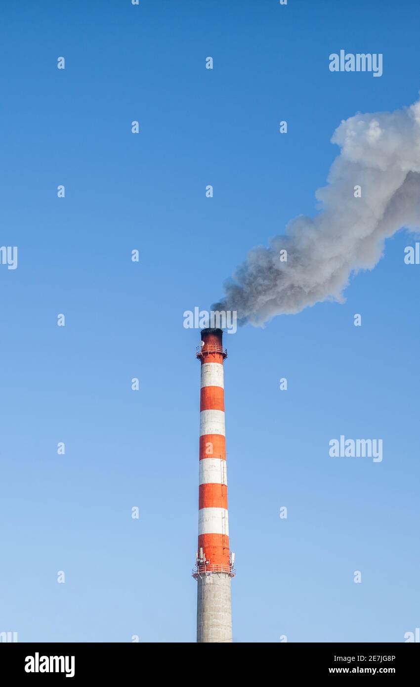 Fumo bianco spesso dal camino del locale caldaia. Fumo contro il cielo blu. Inquinamento atmosferico. Riscaldamento della città. Zona industriale. Foto Stock
