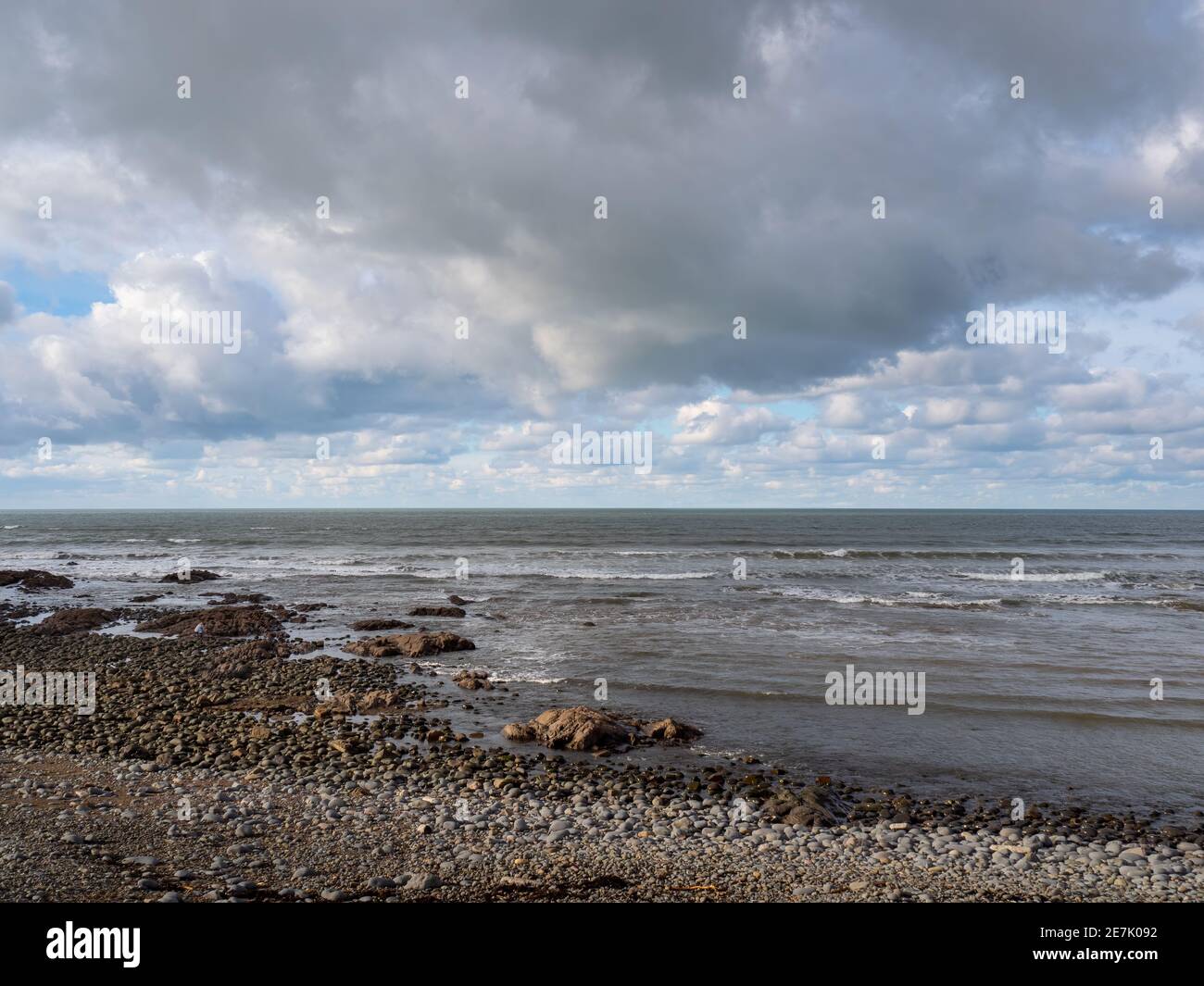 Wintry spiaggia di ciottoli, Regno Unito, generico, con il cielo grigio tempestoso. Foto Stock