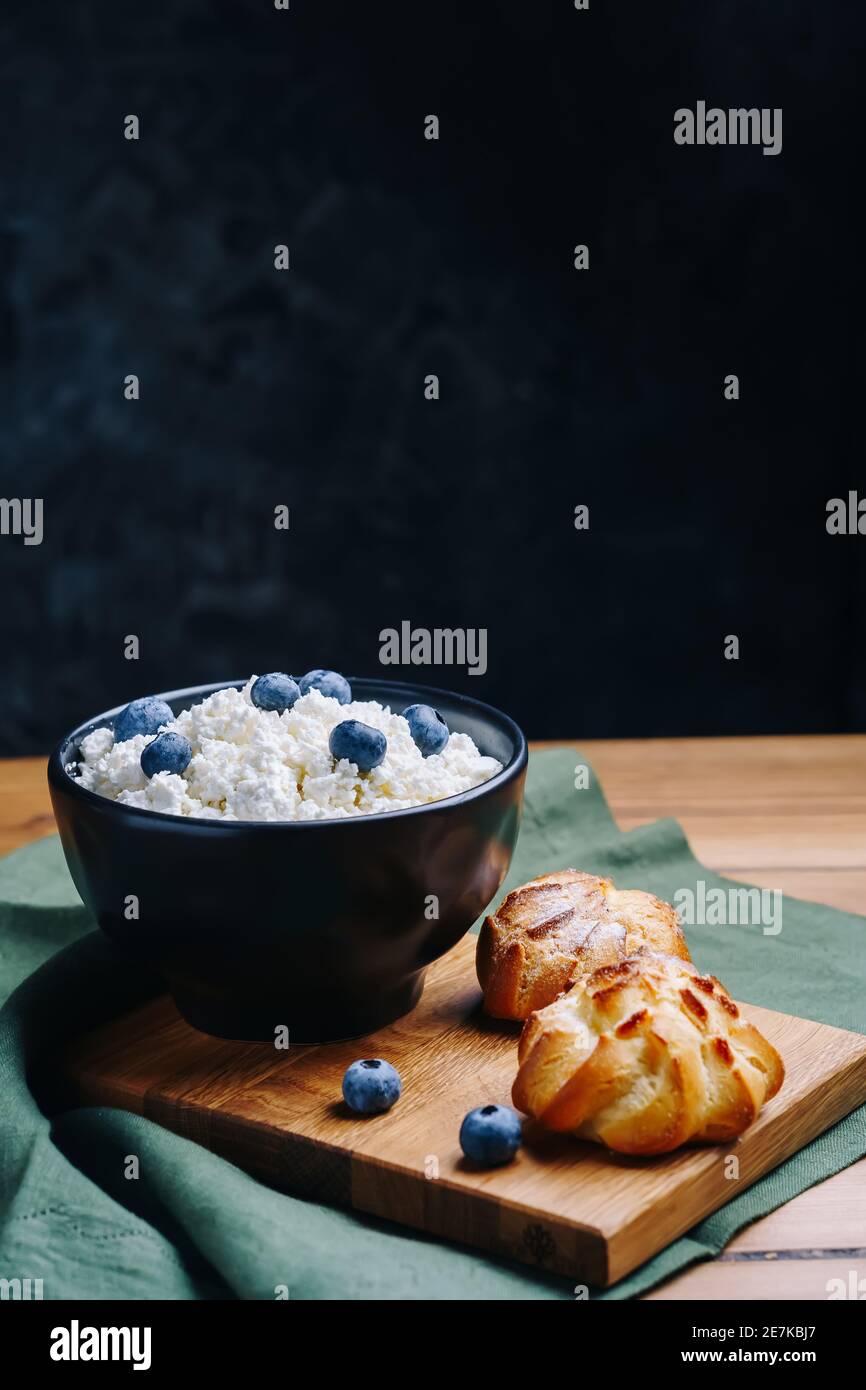 Cottage formaggio in ciotola. Formaggio di cagliata fatto in casa servito con ribes o mirtillo. Concetto di colazione salutare. Foto Stock