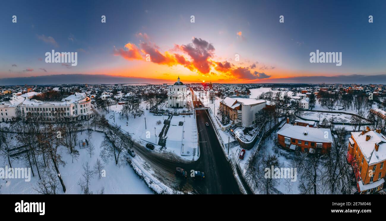 Vista panoramica aerea della cattedrale e della chiesa nella piccola città europea coperta di neve al luminoso tramonto d'inverno splendidi tramonti e nuvole. Drone. Wint Foto Stock