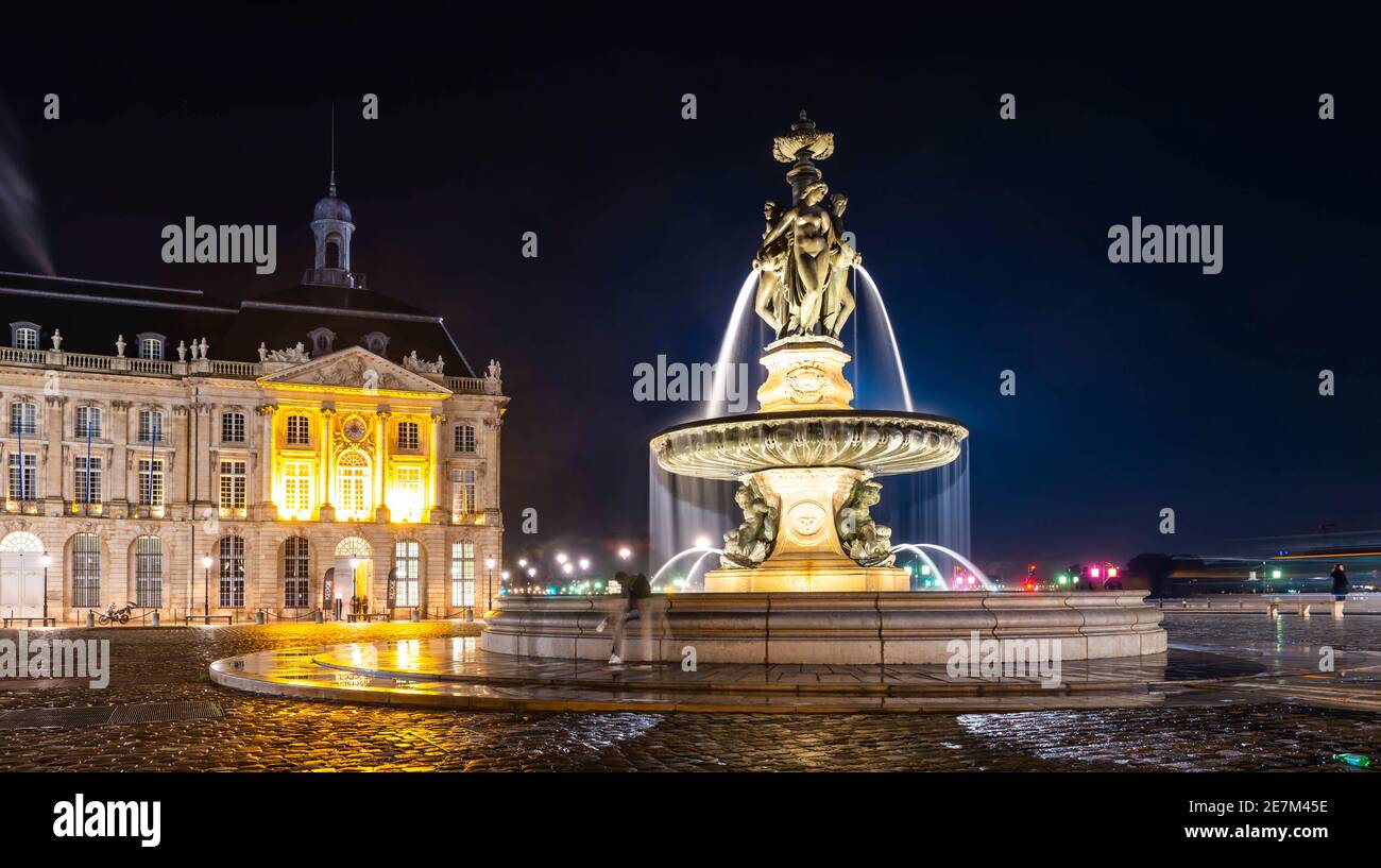 Tram che passa la Cattedrale di Bordeaux di notte a New Aquitaine, Francia Foto Stock