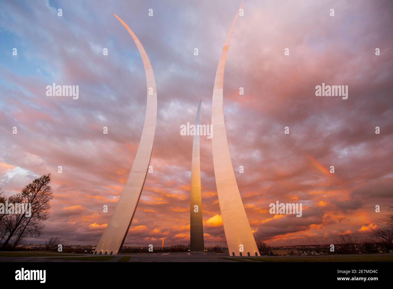 Un arcobaleno può essere visto come il cielo illumina oro e rosa durante un tramonto al United States Air Force Memorial ad Arlington, Virginia. L'hono memoriale Foto Stock