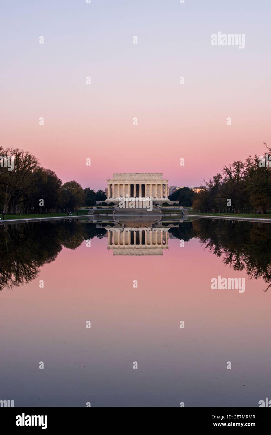 Un cielo rosa e l'iconico Lincoln Memorial in marmo d'avorio si specchiano nella piscina riflettente in una frizzante mattinata d'autunno a Washington, DC. Si trova presso il Foto Stock