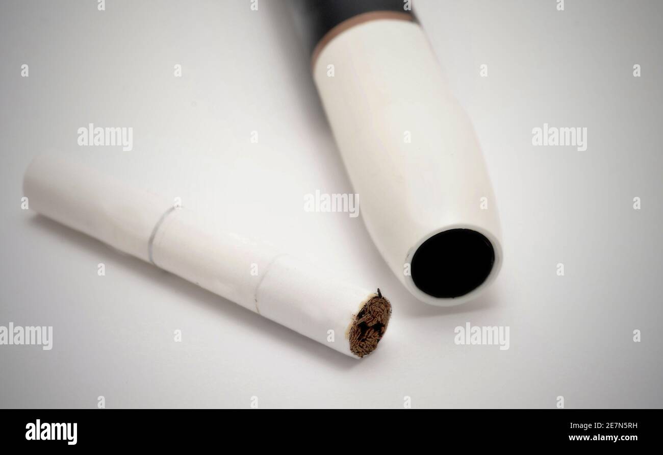 Non bruciare il riscaldatore elettronico di sigaretta con il bastoncino di tabacco su sfondo bianco. Foto Stock