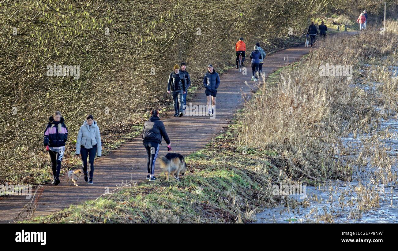 Glasgow, Scotland, UK.30th gennaio, 2021, Lockdown Sabato e un imballato forh e clyde canale vedere le persone che prendono la loro eccecise accanto al congelato acqua. Miseria continua almeno la pioggia si fermò come strade deserte nel centro città, le aree commerciali si basa in manifesti e muro arte come un sostituto per la vita. Credit Gerard Ferry/Alamy Live News Foto Stock