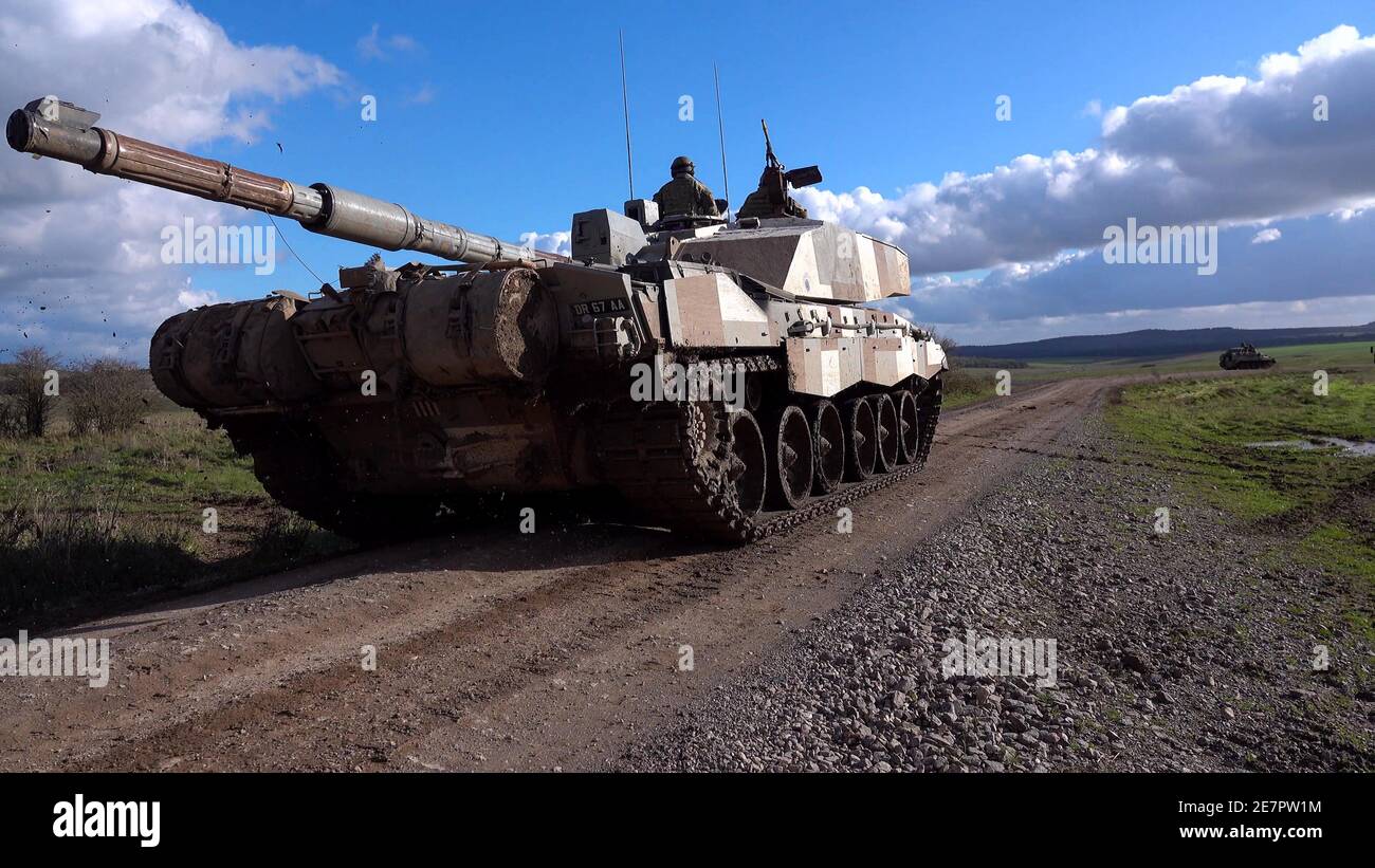 Primo piano di un carro armato di battaglia principale Challenger 2 dell'esercito britannico in azione che dimostra la potenza di fuoco sul campo di addestramento militare Salisbury Plain, Wiltshire Foto Stock