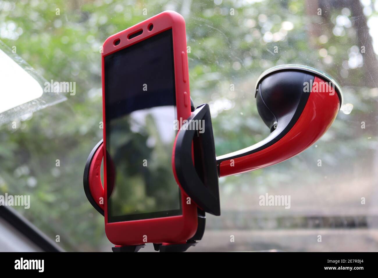 Un telefono cellulare con un supporto telefonico in rosso, in auto. Foto Stock