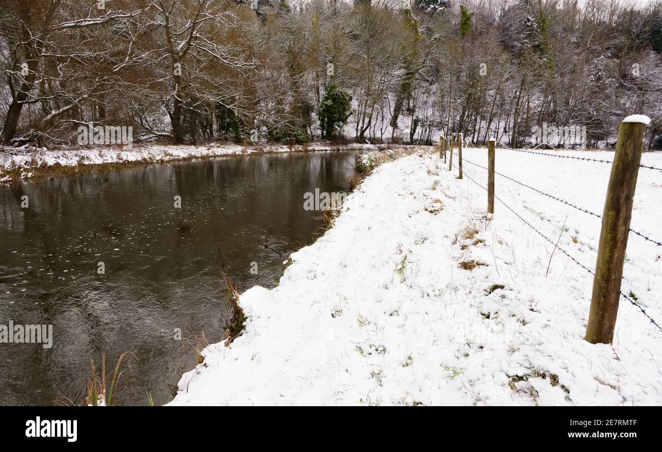 inverno panoramico lungo un fiume ad una curva con neve banche coperte Foto Stock