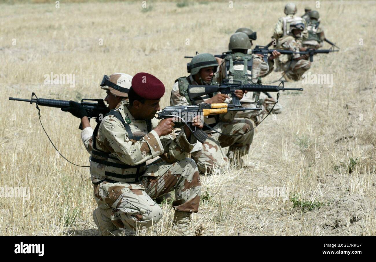 Iraqi soldiers take up position during a joint military operation with U.S. forces in a village in Mahmoudiya, 30km (20 miles) south of Baghdad April 16, 2008. About five suspected insurgents were arrested and weapons cache found during a raid conducted by U.S. and Iraqi forces in a village in Mahmoudiya, Iraqi army said. REUTERS/Ibrahim Sultan (IRAQ) Foto Stock
