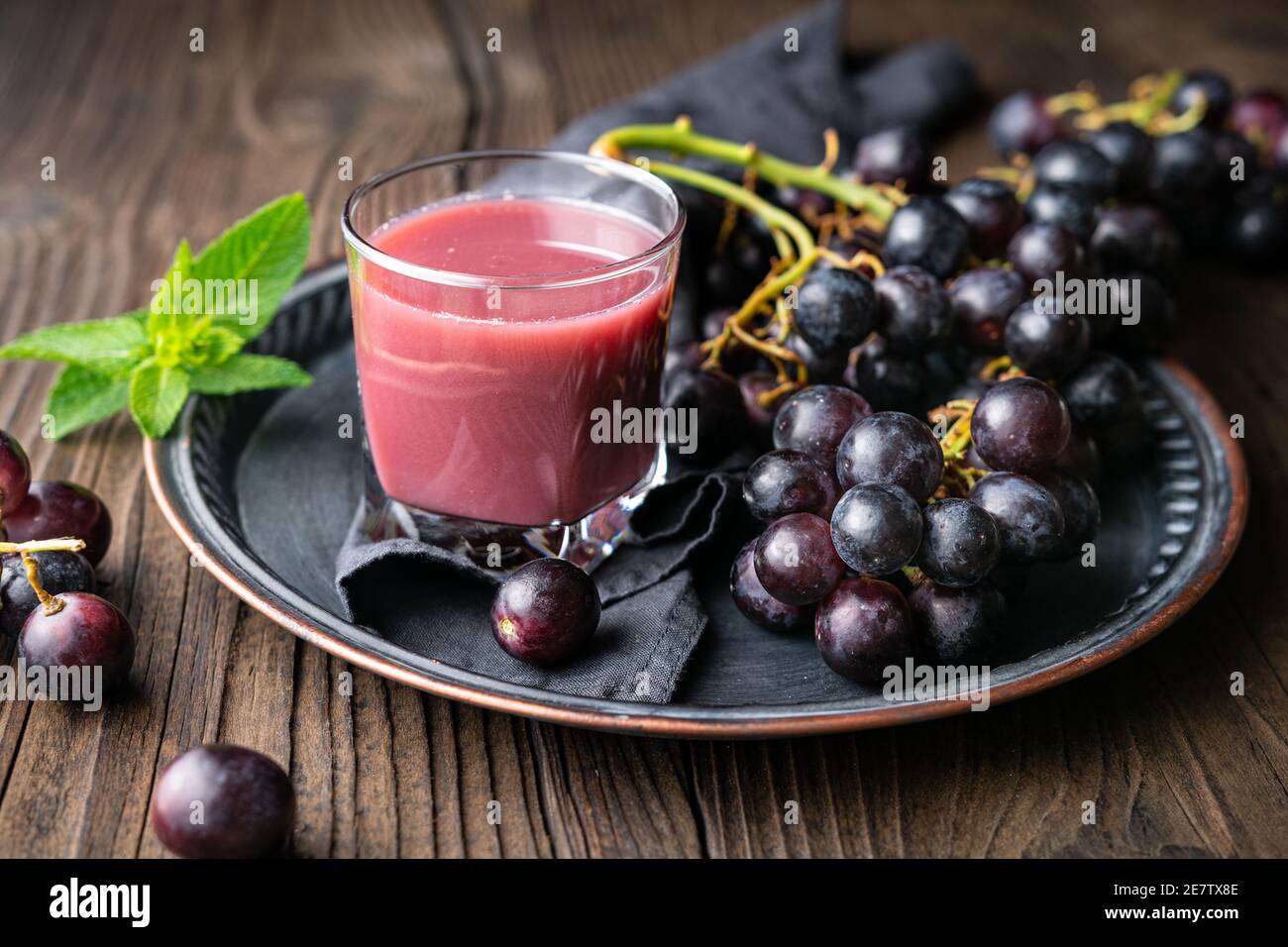 Bevanda fatta in casa di stagione, succo d'uva appena fatto in vaso di vetro su rustico sfondo di legno Foto Stock
