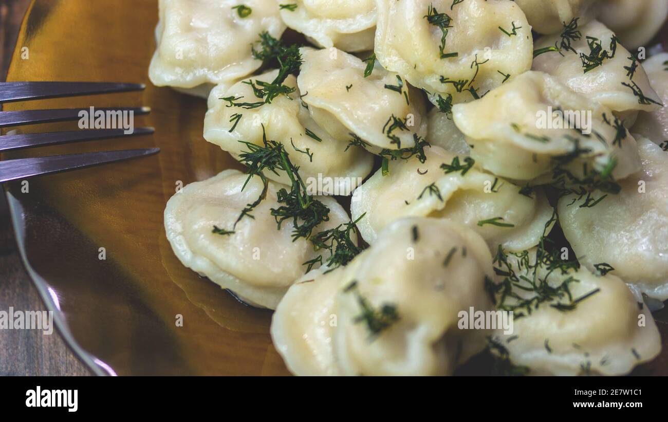Gnocchi russi con erbe, gnocchi fatti in casa in un piatto decorato con aneto, cibo fatto in casa. Foto Stock