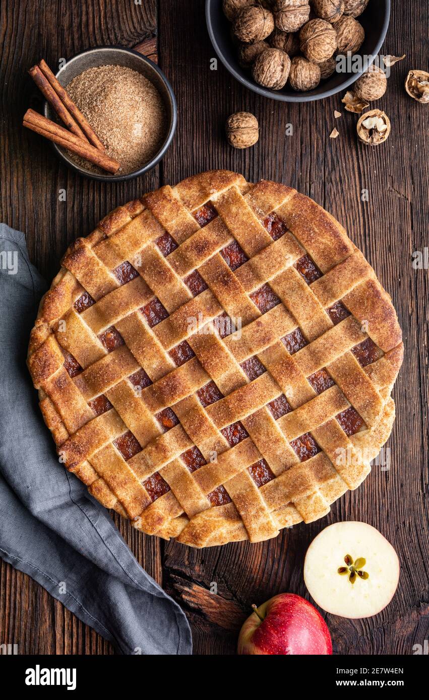 Dessert fatto in casa, torta di crosta a graticcio vecchio stile con ripieno di mela grattugiata e noce, cosparsa di zucchero granulato e cannella su un bosco rustico Foto Stock