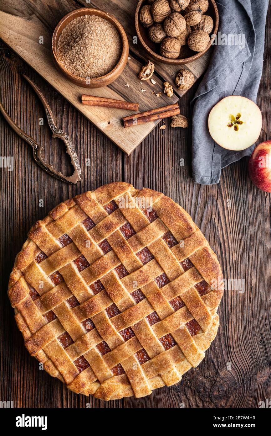 Dessert fatto in casa, torta di crosta a graticcio vecchio stile con ripieno di mela grattugiata e noce, cosparsa di zucchero granulato e cannella su un bosco rustico Foto Stock